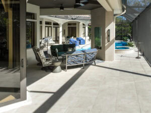 a pool deck with chairs and a pool finished with porcelain tiles