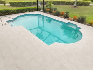 porcelain tile pool with a deck and a lawn