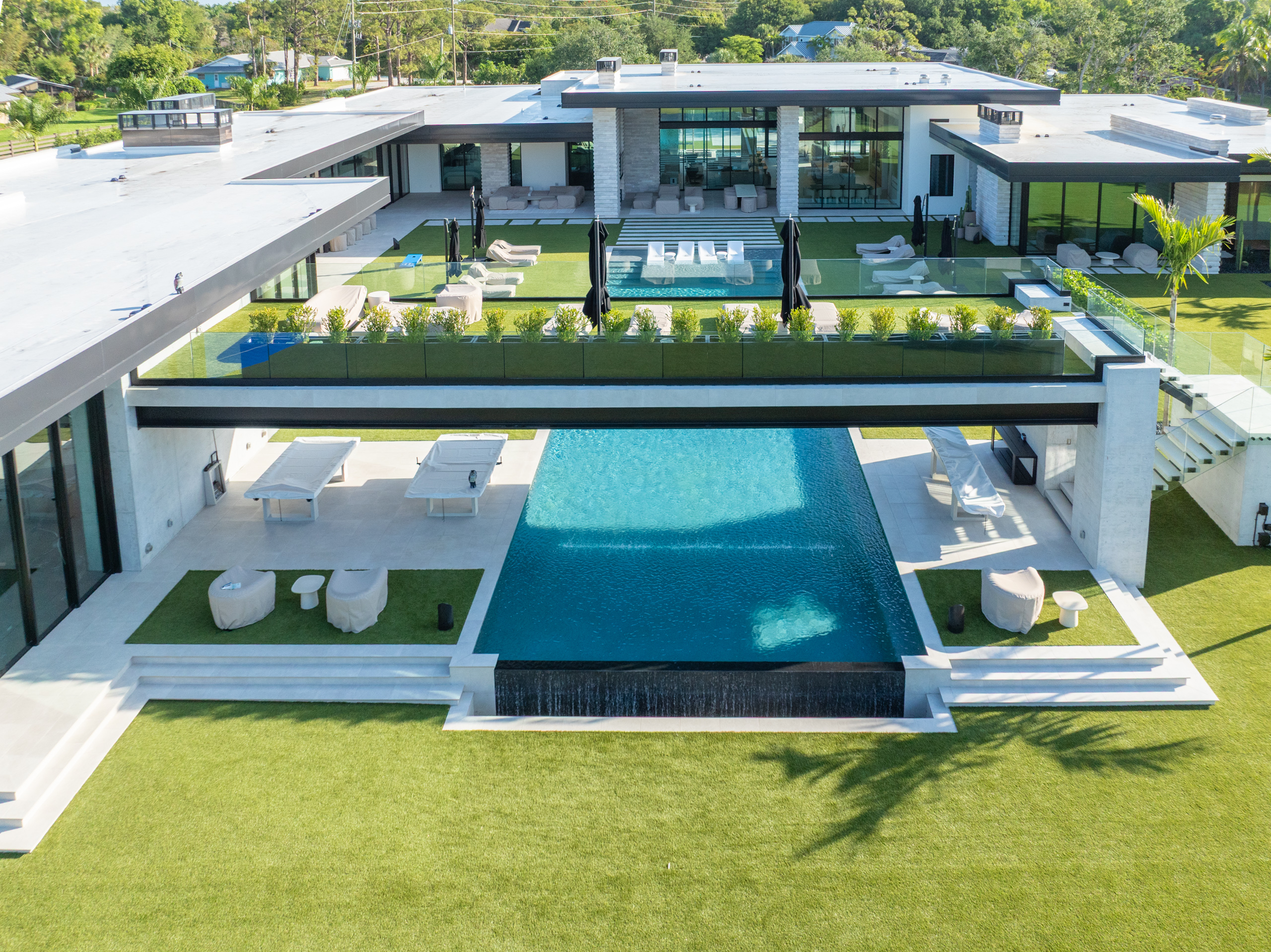 outdoor living area transformation by accurate pavers, pool, deck, turf
