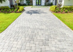 paved driveway with a white house and trees