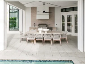 Modern outdoor dining area by pool, paved pool deck