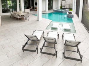 Modern poolside with lounge chairs - paved pool deck