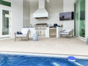 outdoor kitchen with paved pool deck