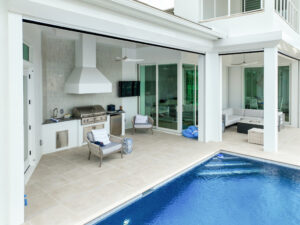 outdoor kitchen with paved pool deck