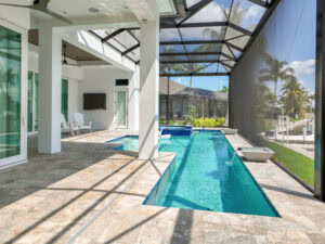 Modern pool area with screened enclosure and paved pool deck