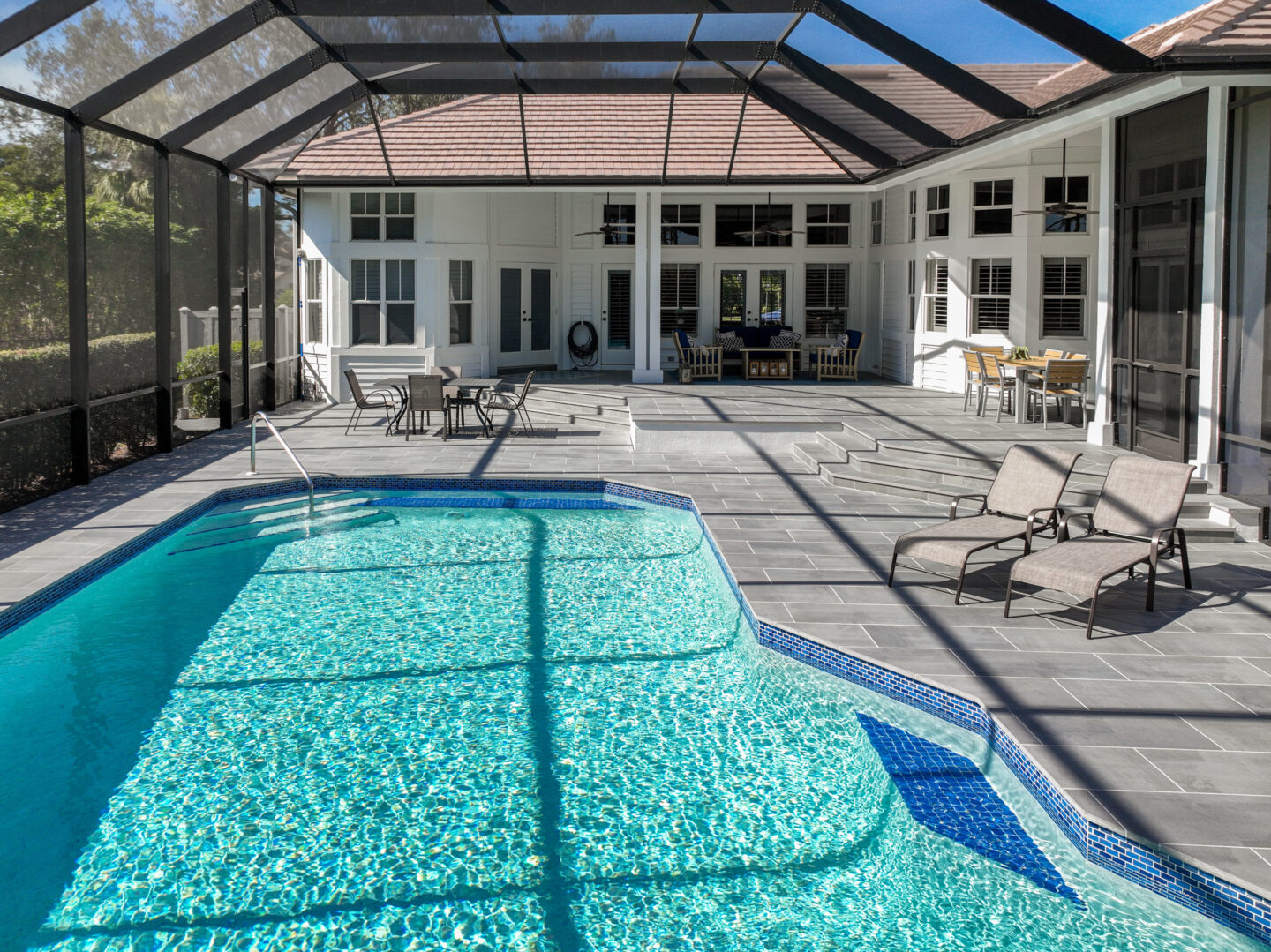 Modern paved poolside patio with loungers