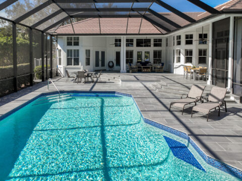 Modern paved poolside patio with loungers