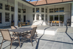Spacious outdoor patio paved with porcelain pavers with furniture.