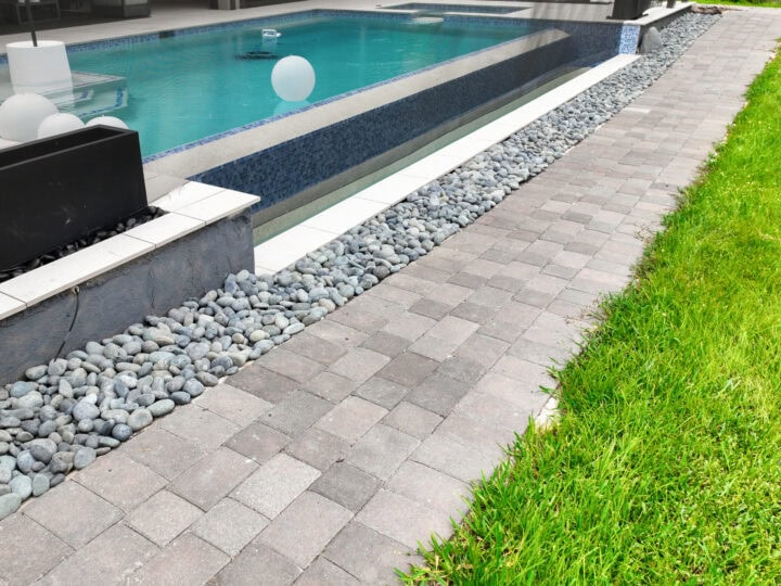 paved walkway next to the pool